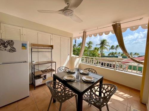 a kitchen with a table and chairs and a refrigerator at Studio Ti Zandoli in Sainte-Anne