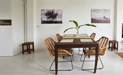 einem Esstisch mit Stühlen und einer Pflanze darauf in der Unterkunft The Banana Tree House in Ban Ta Kun