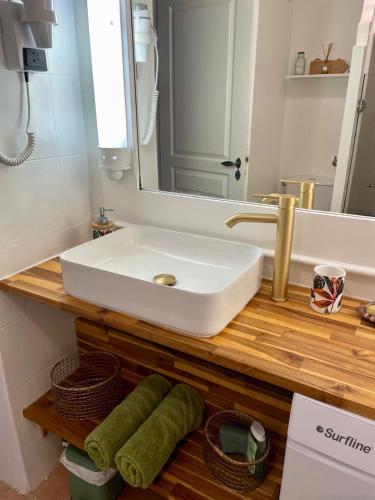 a bathroom with a white sink and a mirror at Studio Ti Zandoli au cœur du village in Sainte-Anne