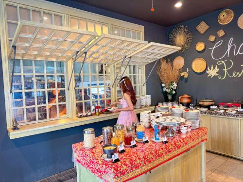 una niñita parada en un mostrador en una cocina en Thai Fight Hotel, en Lamai