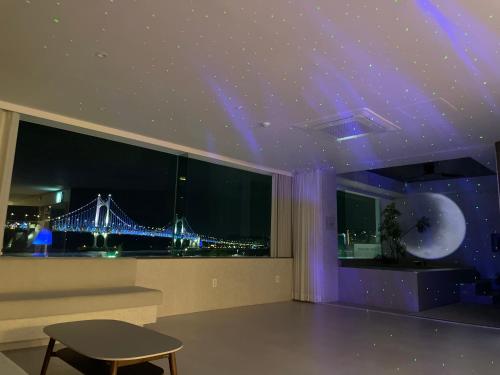 a room with a view of a bridge with purple lights at 광안사계스테이 GwanganSagyeStay in Busan