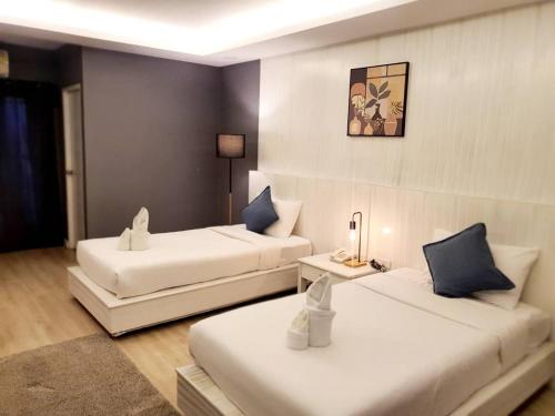 a hotel room with two beds and a table at Curve Boutique Hotel in Pattaya Central
