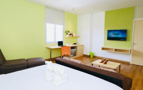 a living room with a couch and a tv at Zest Jemursari by Swiss-Belhotel International in Surabaya