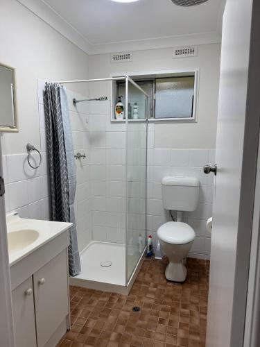 a bathroom with a shower and a toilet and a sink at Walcha Villas in Walcha