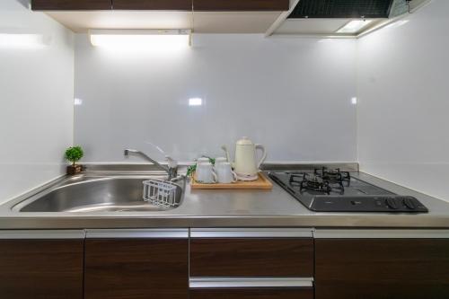 a kitchen with a sink and a stove at ルーベンス博多 in Fukuoka