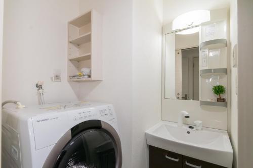 a laundry room with a washing machine and a sink at ルーベンス博多 in Fukuoka