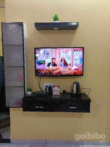 a flat screen tv on a wall at Bhavya Homstayes in Ujjain