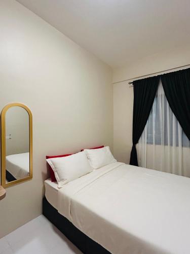 ein Schlafzimmer mit einem großen Bett und einem Spiegel in der Unterkunft WiU Cottage, Seri Iskandar in Seri Iskandar