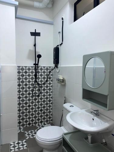 ein Badezimmer mit Toilette, Waschbecken und Spiegel in der Unterkunft WiU Cottage, Seri Iskandar in Seri Iskandar