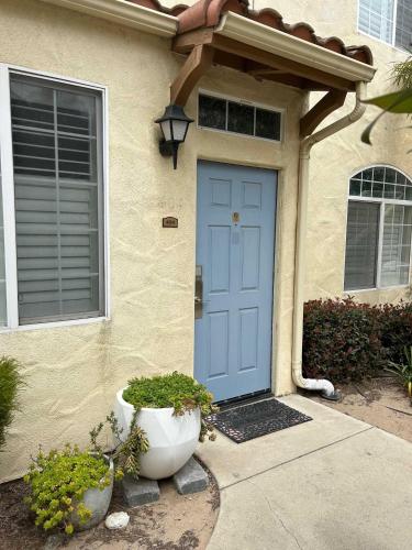 a blue door of a house with two potted plants at Sandy Toes Studio in Oceano