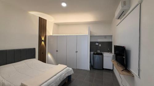 a small bedroom with a bed and a kitchen at Maison Áurea Loft in Cali