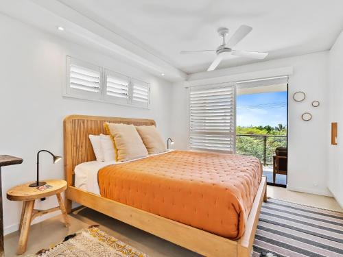 a bedroom with a large bed and a window at Oceanbreeze - Sunshine Beach Ocean Views in Sunshine Beach