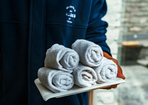 a person holding a tray full of towels at Mountain Lodges of Nepal Manang in Manangbhot