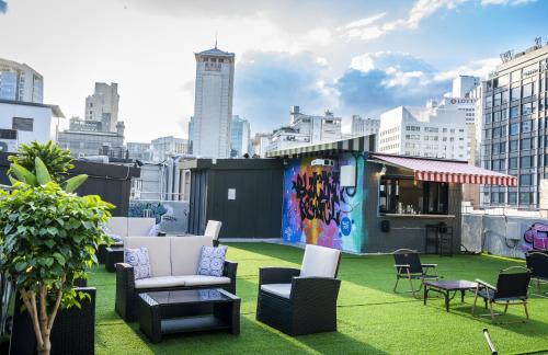 Un patio en la azotea con sillas y mesas en un edificio. en Bluedot Poshtel, en Seúl
