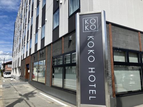 a sign on the side of a building at KOKO HOTEL Hidatakayama - formaly Hotel Wing Hida Takayama in Takayama