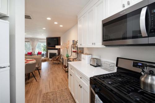 a kitchen with white cabinets and a stove top oven at Blacklake Resort Vacation Rental Nestled on the 9t in Los Berros