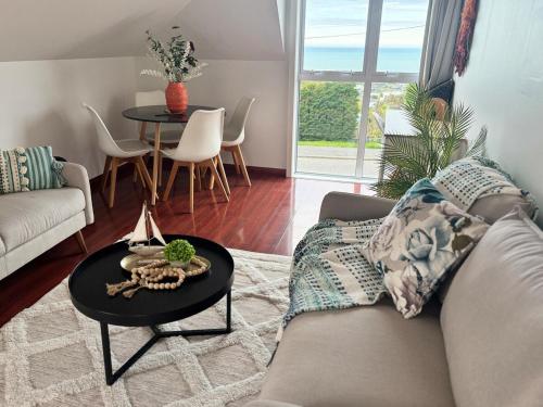 un salon avec un canapé et une table dans l'établissement Belleview Cottage- Cute cottage with views of sea, city and snowpeeks, à Christchurch