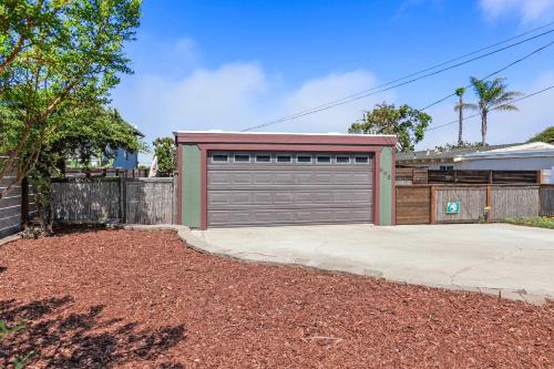 a house with a garage door and a driveway at The Bay Escape in Cuesta-by-the-Sea