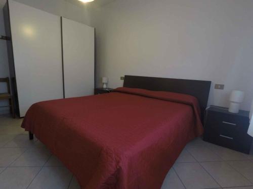 ロザピネタにあるApartment in Rosolina Mare 34864の赤いベッドカバーがかかったベッドのある寝室