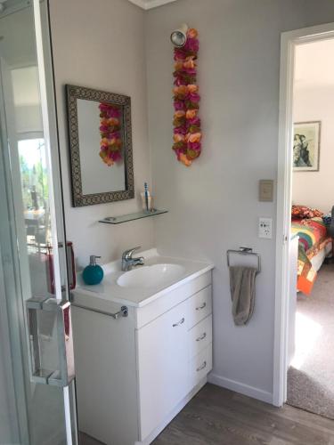 a bathroom with a sink and a mirror at First Light in Mangawhai