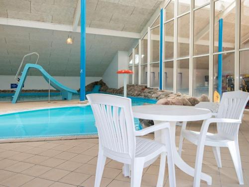 a pool with a table and chairs and a slide at 4 person holiday home on a holiday park in Hemmet in Hemmet