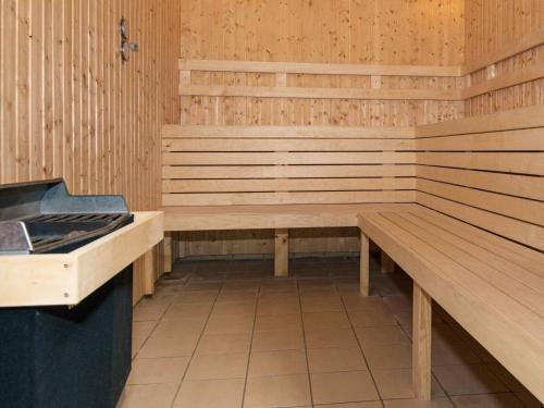 a sauna with wooden benches and a stove at 4 person holiday home on a holiday park in Hemmet in Hemmet