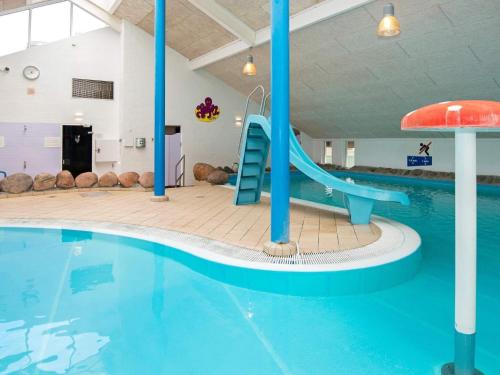 a swimming pool with a slide in a building at 6 person holiday home on a holiday park in Hemmet in Hemmet