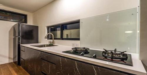 a kitchen with a stove and a sink at Asri loka villa in Ubud