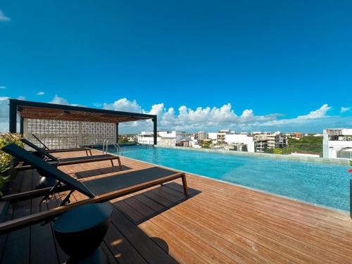 un balcon avec une piscine sur le toit d'un immeuble dans l'établissement Zuhause Apartments 5th AV, à Playa del Carmen