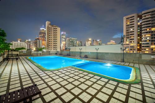 een zwembad bovenop een gebouw met een skyline van de stad bij Fully Furnished Omni Tower Apartments Nana - Sukhumvit soi 4 in Bangkok