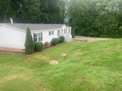 a white house with a yard with a house at Spacious Modular Rental on Huge Horse and Cattle Farm near Charlottesville, Virginia in Gordonsville