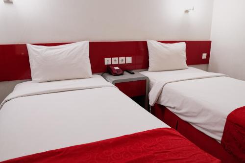 una habitación con 2 camas y un teléfono. en Brothers Inn Solo Baru, en Temulus