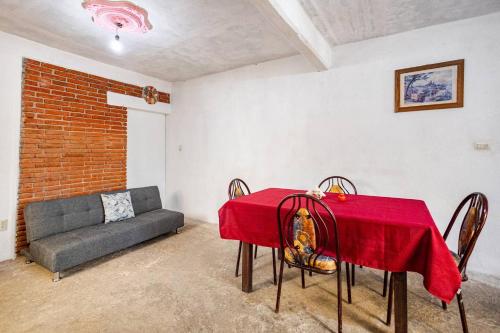 a living room with a red table and a couch at Cómodo y acogedor departamento in Oaxaca City