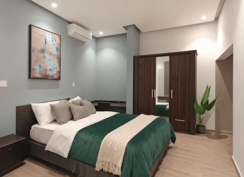 a bedroom with a large bed and a mirror at Roushan Resort Salalah Mirbat in Mirbāţ