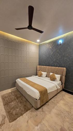 a bedroom with a bed with a ceiling fan at Vraj in Vrindāvan