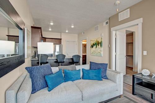 sala de estar con sofá gris y almohadas azules en Spacious 2-Bedroom Urban Oasis, en Salt Lake City