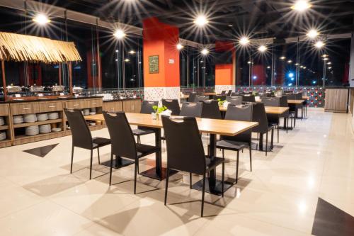 Un comedor con mesas, sillas y luces. en Brothers Inn Solo Baru, en Temulus