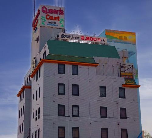 a white building with a sign on top of it at Hotel Queen's Court -ホテル クインズコート- in Okayama