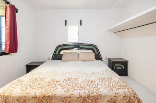 a bed in a white room with two nightstands and a bed with at Cómodo y acogedor departamento in Oaxaca City
