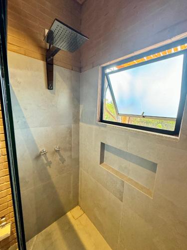 a bathroom with a shower with a window at Chalé Caroá in São Raimundo Nonato