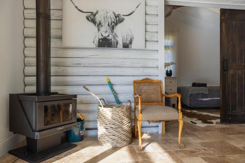 a fireplace in a living room with a cow picture on the wall at Webbs Creek Farm Retreat in Wisemans Ferry