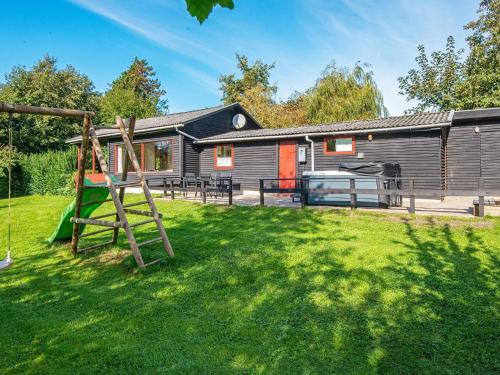 een huis met een tuin met een speeltuin bij 6 person holiday home in Sydals-By Traum in Østerby