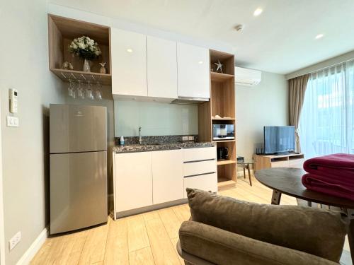 a kitchen with white cabinets and a table at Diamond Condo apart near Bangtao beach in Bang Tao Beach