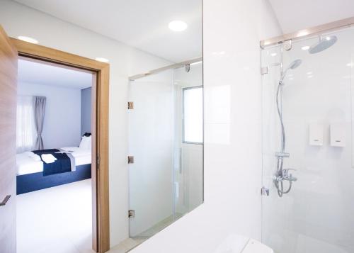 a bathroom with a shower and a toilet and a bedroom at Nordic Hotel Abuja in Abuja