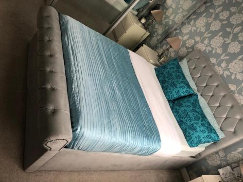 1 cama con sábanas y almohadas azules en una habitación en Quaint and Peaceful - Calne, en Calne