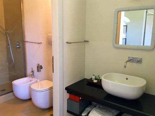 a bathroom with a sink and a toilet and a mirror at Locanda Palazzone in Orvieto