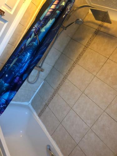 twee blauwe paraplu's op de vloer van een badkuip bij Quaint and Peaceful - Calne in Calne