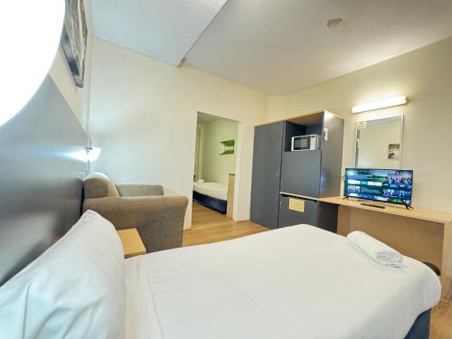 a hotel room with a bed and a tv at Taree Motor Inn in Taree