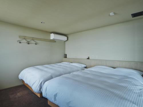 Dos camas una al lado de la otra en una habitación. en 青々 -aoao-, en Taisya