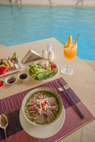 ニャチャンにあるPanoramas Nha Trang Residencensのスープとドリンクを入れたテーブル